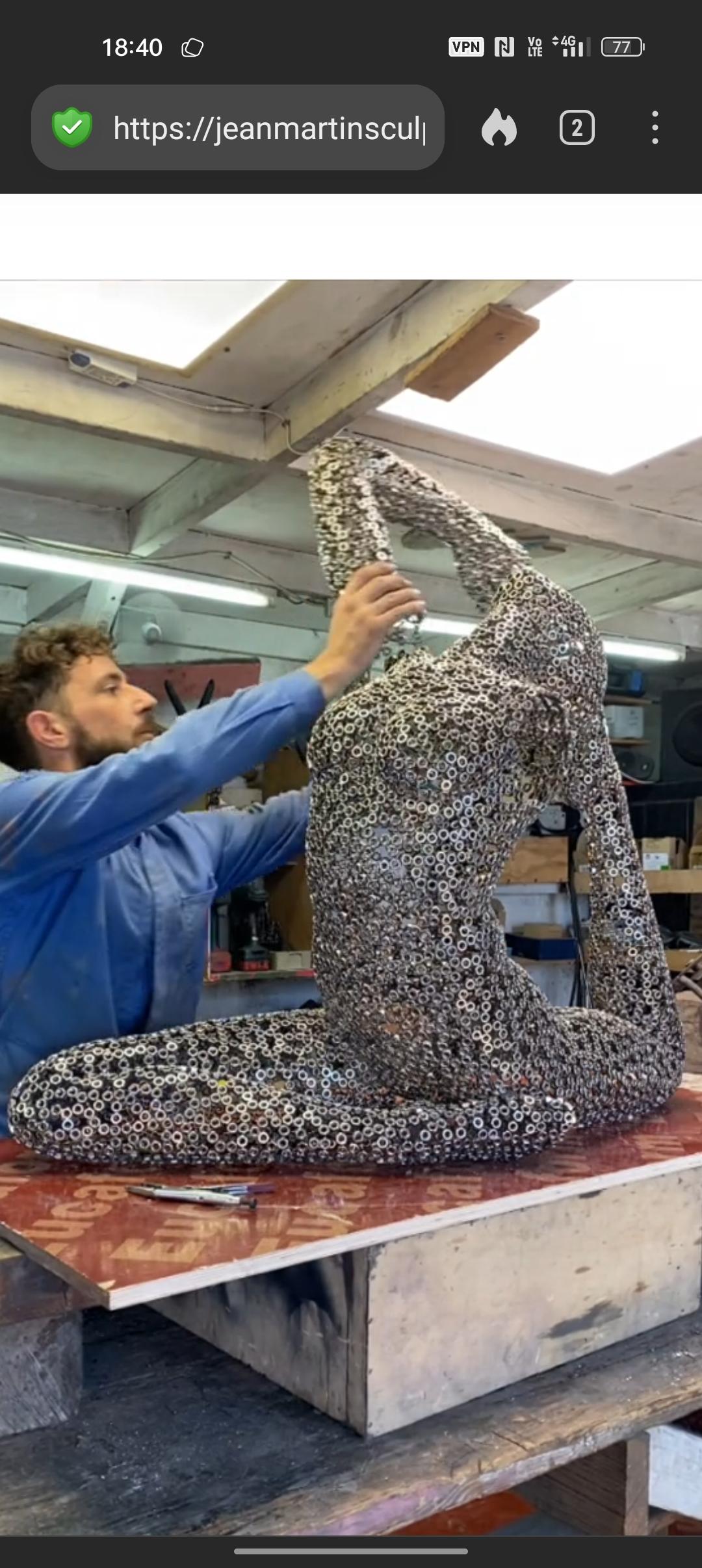Jean Martin welding a sculpture of a female form, from thousands of hexagonal metal nuts.