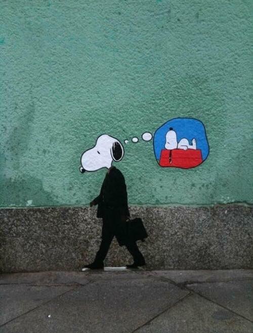 Drawing on a public footpath wall of a black suit and briefcase wearing Snoopy with a thought bubble above his head showing he's thinking of staying home on his fav rooftop place
