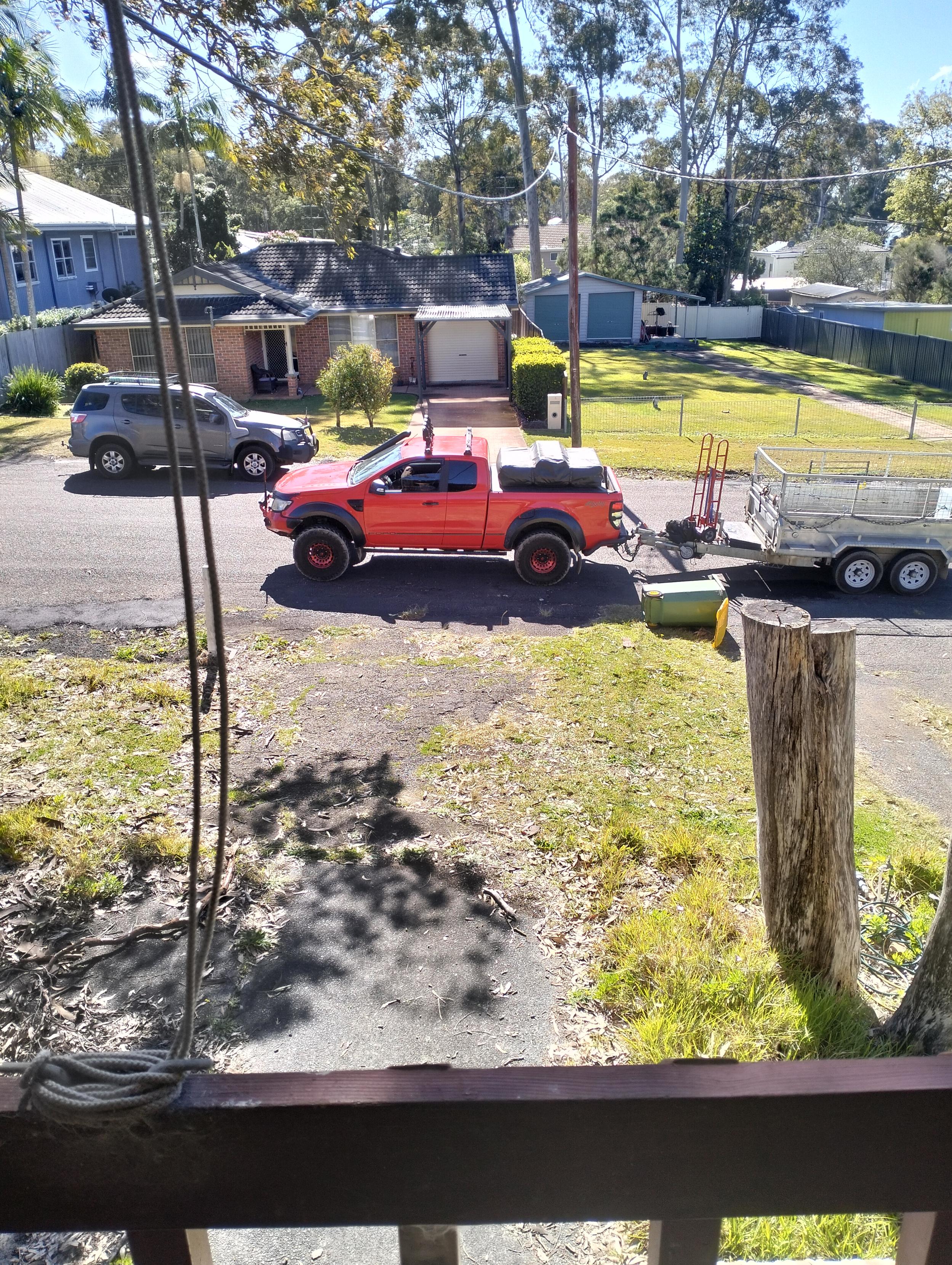 A red ute with trailer, parked across my driveway.